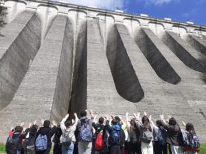 classi terze ai piedi della diga del Brugneto con le mani alzate verso la diga