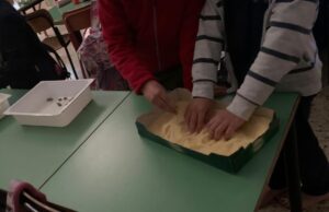 foto di mani di bambini nella vaschetta piena di polenta