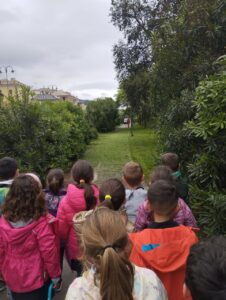 bambini osservano il giardiniere che cura le aiuole del parco Dapelo